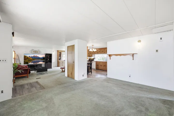 Open concept interior featuring light-toned walls and varied flooring