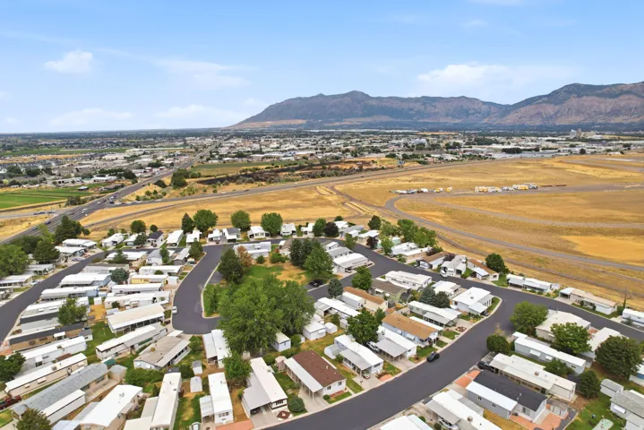 Developed community featuring paved roads, mature trees, and a mountain backdrop