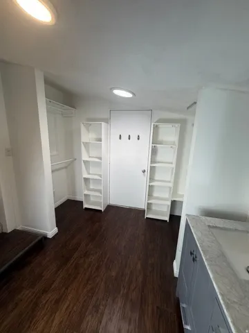 Room featuring rich wood-finish flooring and white walls