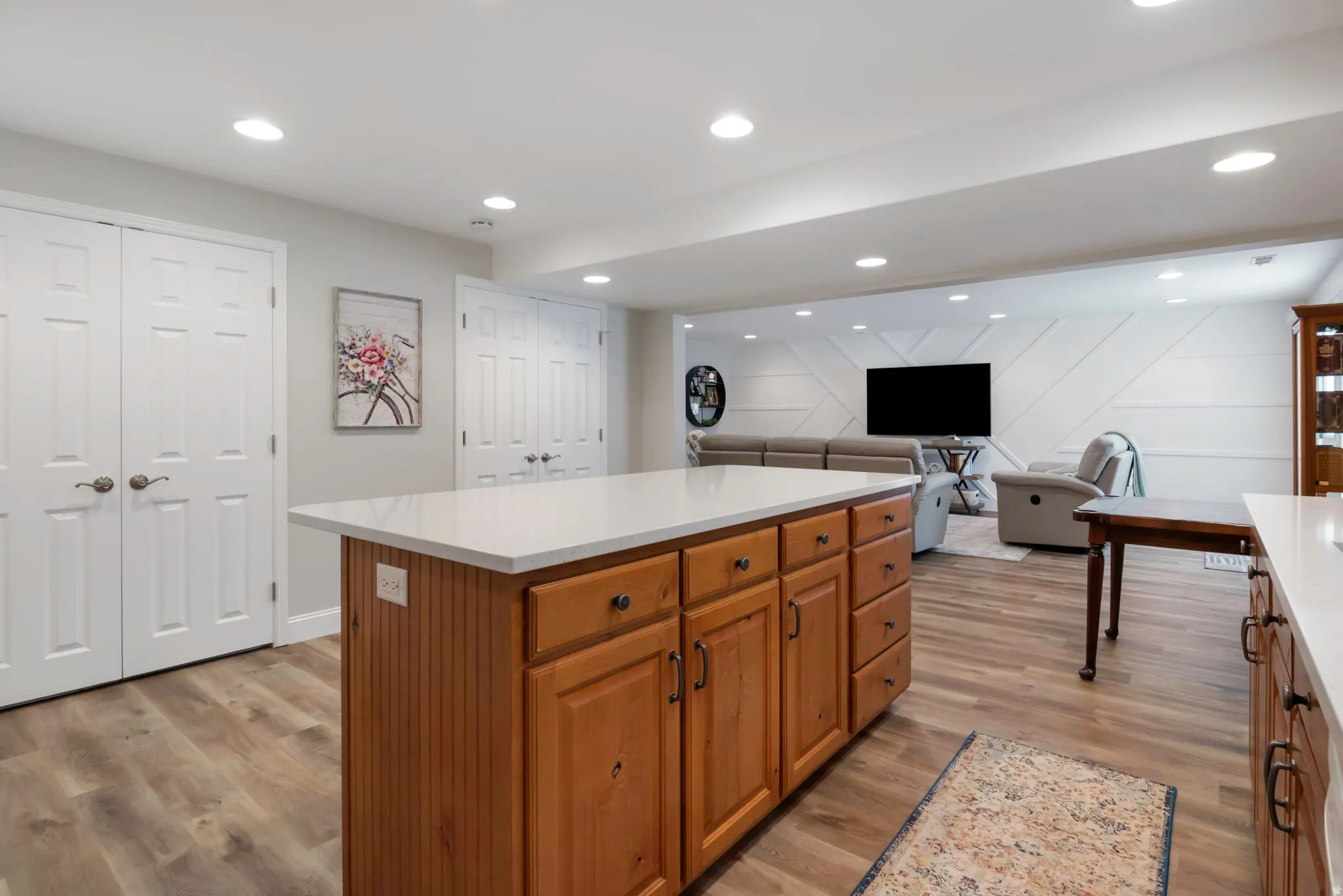 Kitchen island featuring wood cabinetry, a white countertop, and integrated electrical outlets