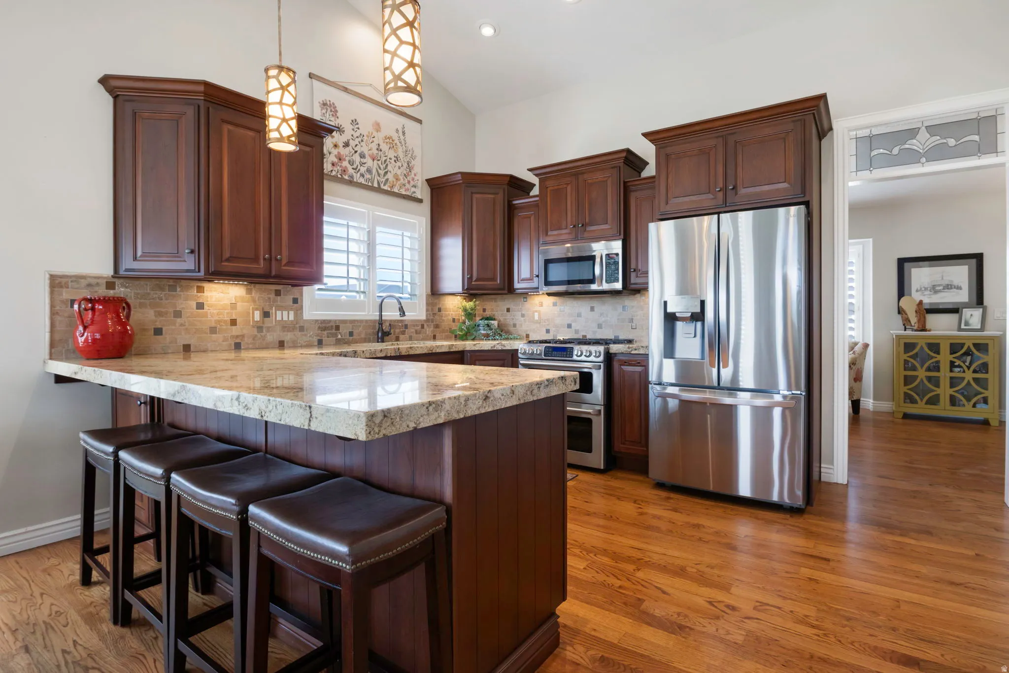 Kitchen featuring wood-finish flooring, custom wood cabinetry, and speckled countertops