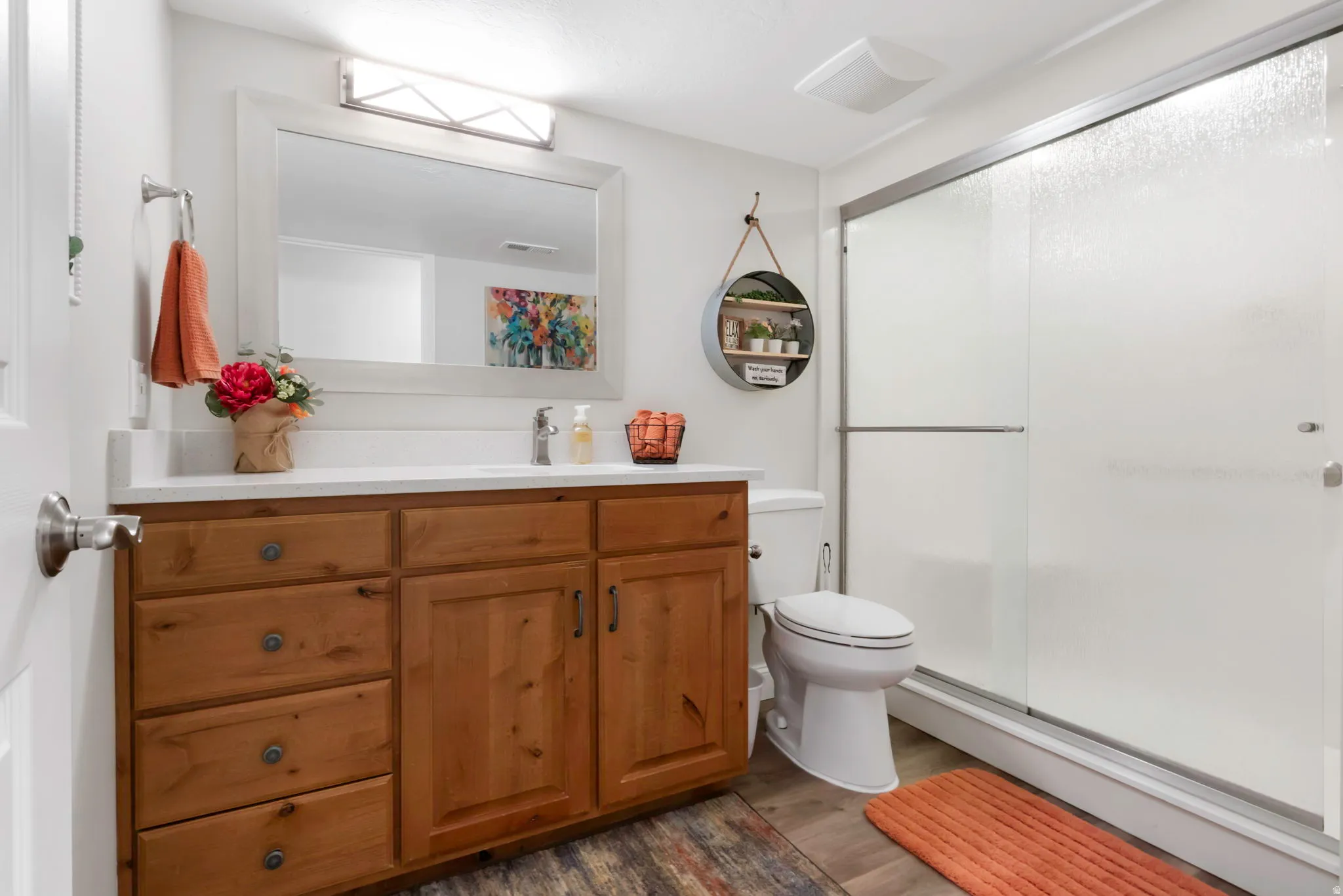 Bathroom featuring a wood-finish vanity with a white countertop and integrated sink