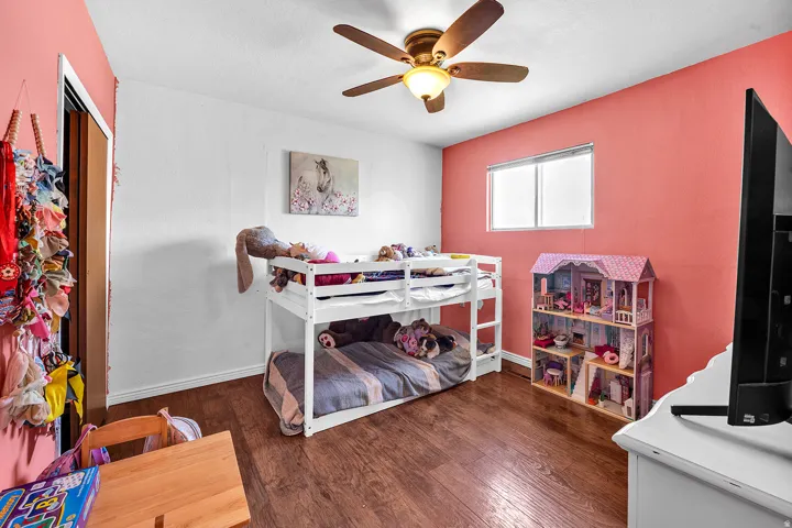 Room with wood-finish flooring, a ceiling fan, and a window providing natural light