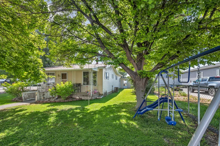 Expansive green lawn with mature shade trees providing ample canopy
