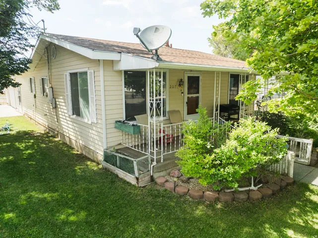 Light-colored siding exterior with a covered front porch featuring decorative metal railing
