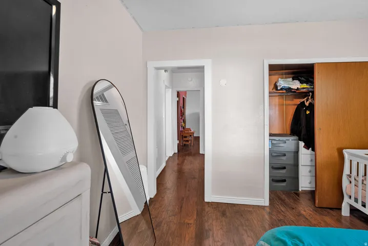 Bedroom featuring wood-finish flooring, light-toned wall paint, and white trim