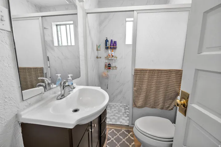 Bathroom featuring a vanity with an integrated sink, polished chrome faucet, and a wall-mounted mirror