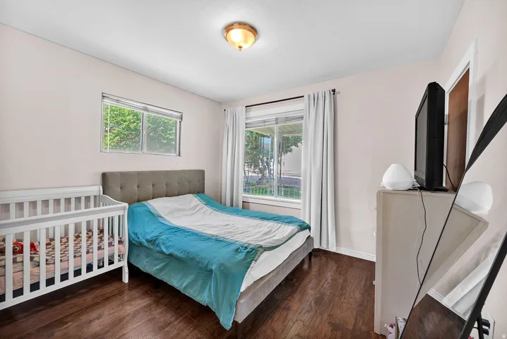 Bedroom featuring wood-finish flooring, light-toned walls, and a ceiling-mounted light fixture
