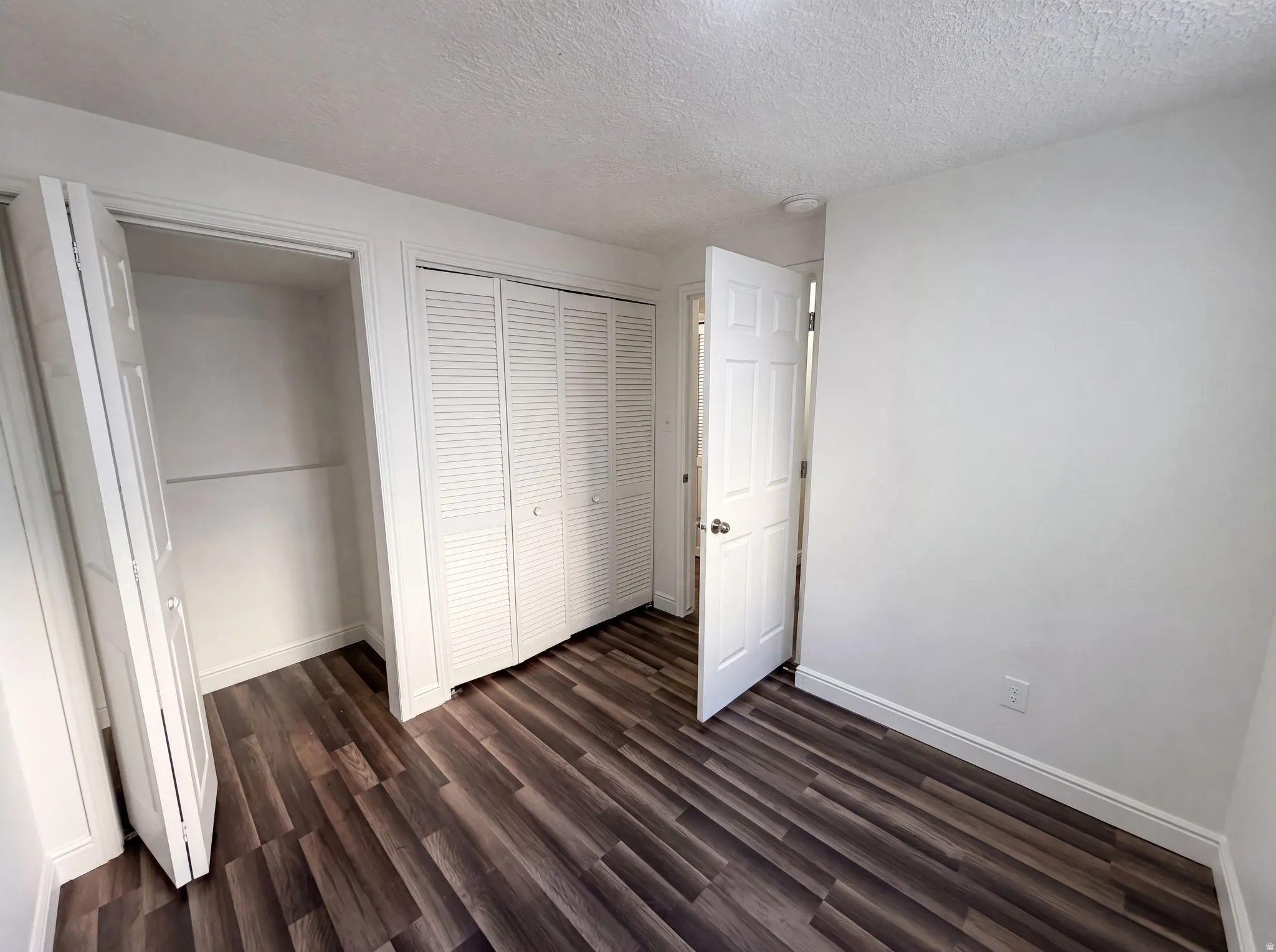 Room featuring wood-finish flooring, white walls, and a recessed ceiling light