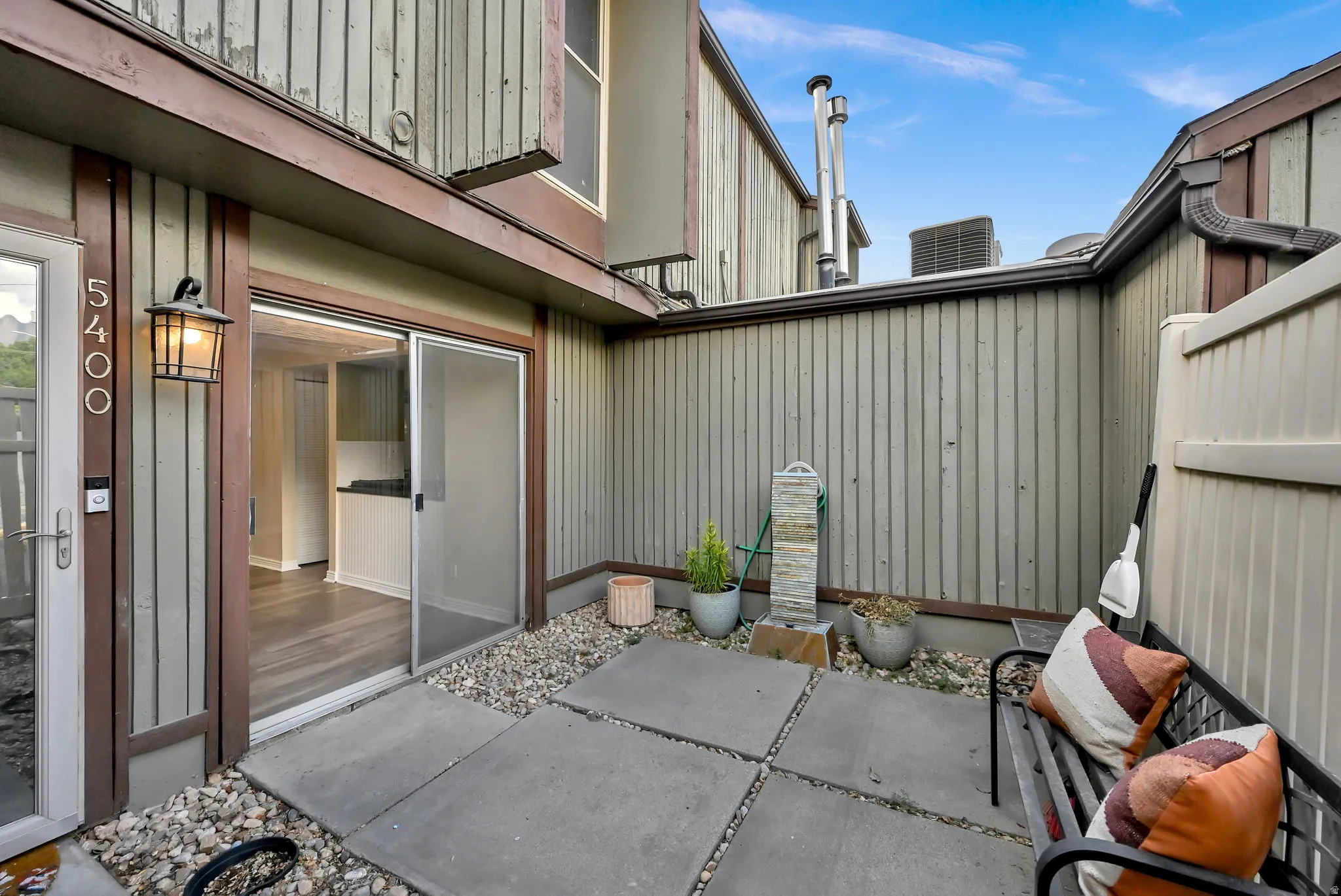 Private exterior patio featuring concrete pavers, pea gravel, and a privacy fence