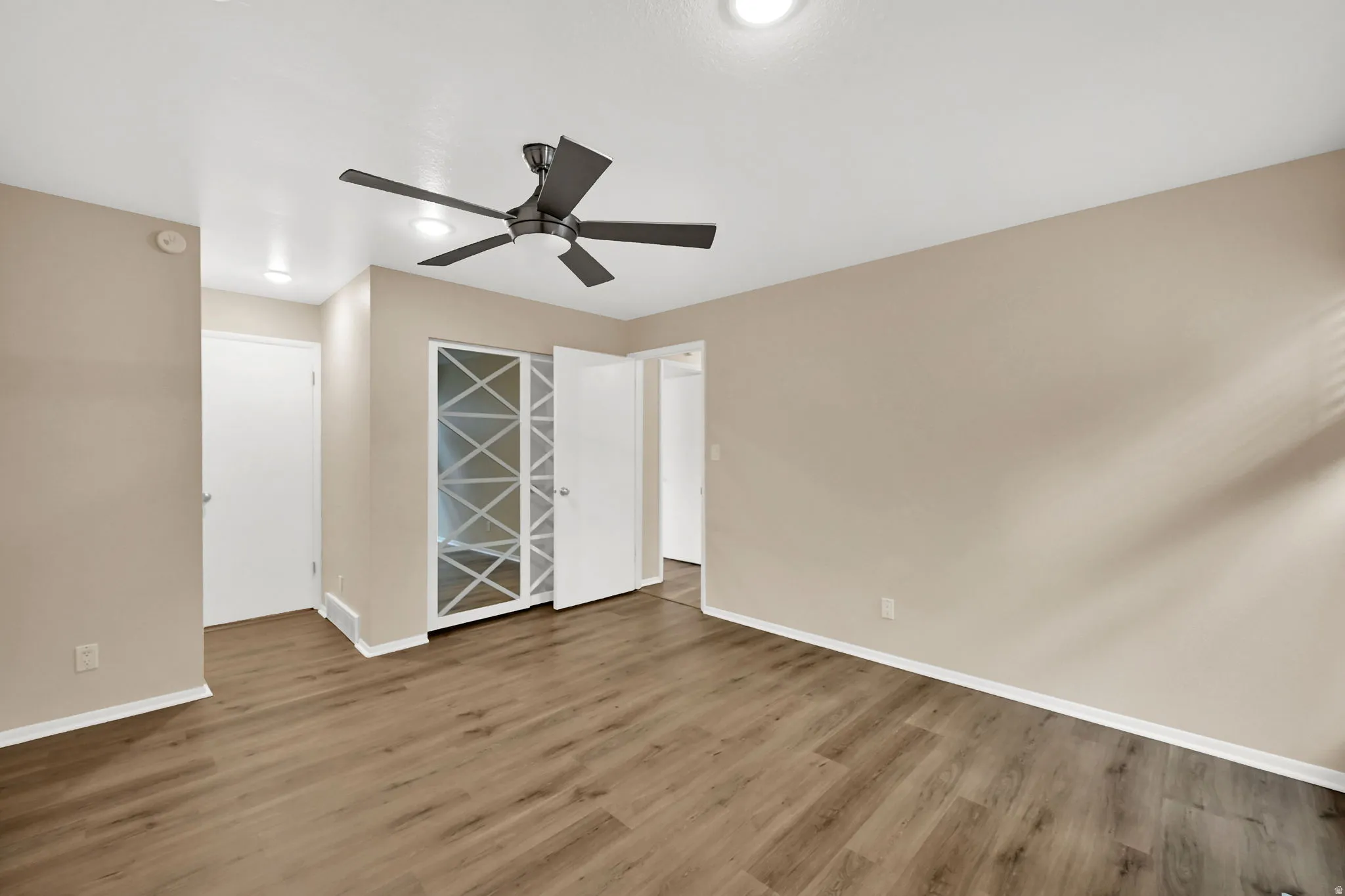 Room featuring wood-finish flooring, recessed lighting, and a modern ceiling fan