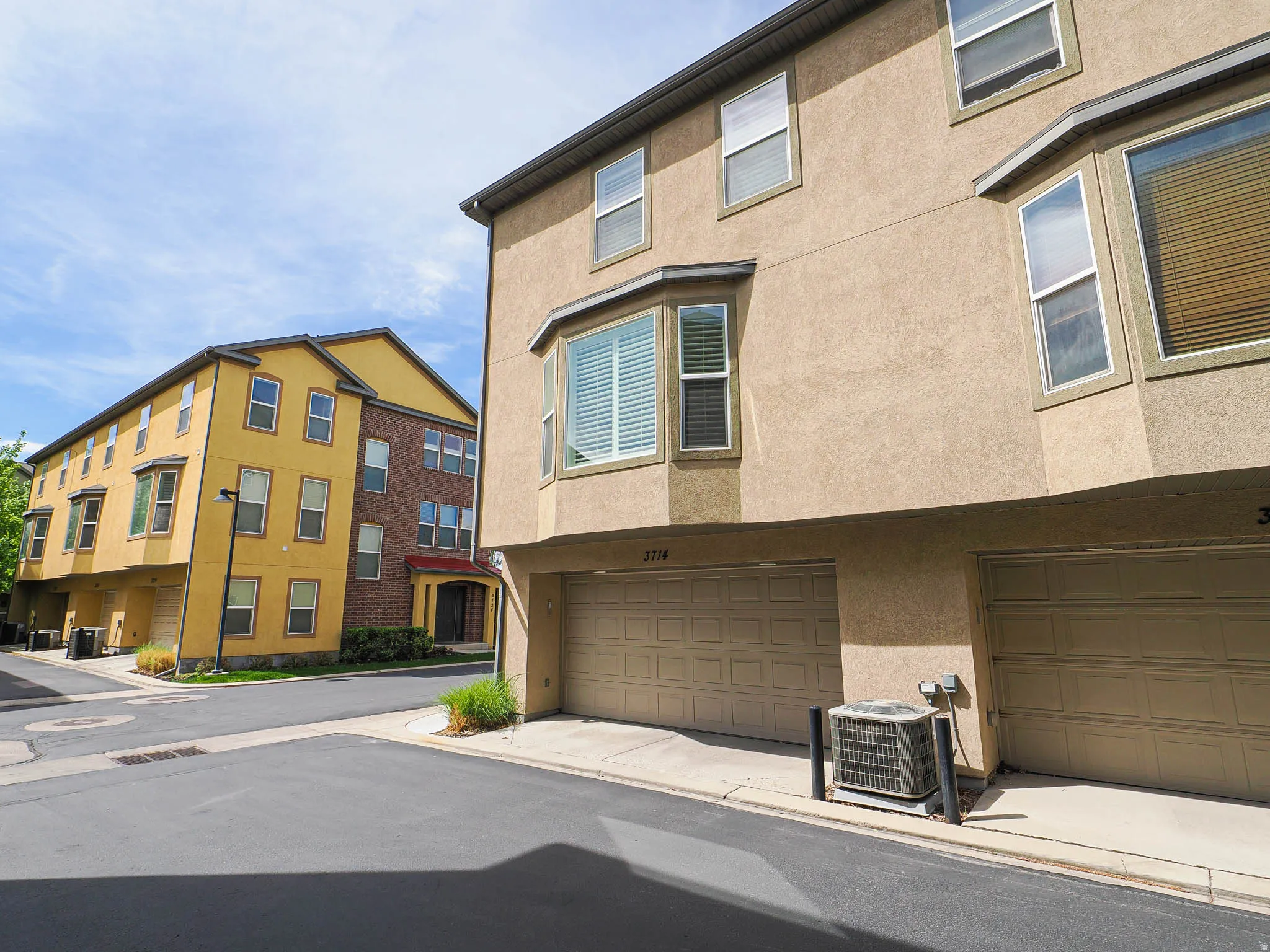 Townhome exterior with stucco finish and multiple bay windows