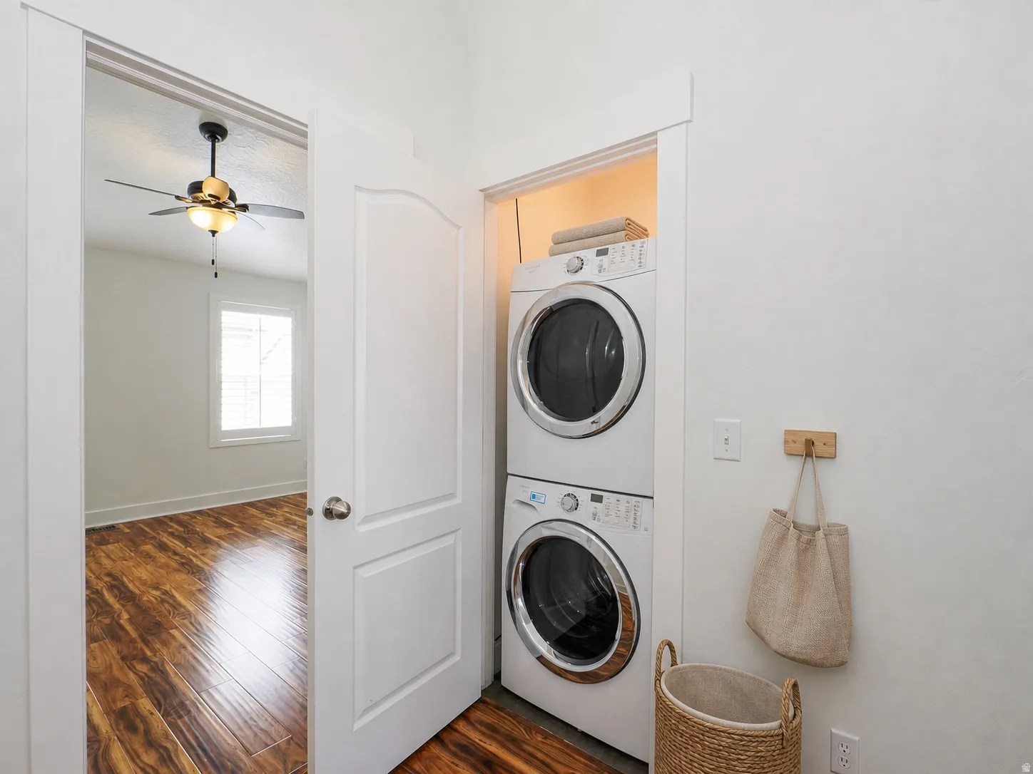 Dedicated laundry area featuring stacked front-load appliances within a white-painted alcove