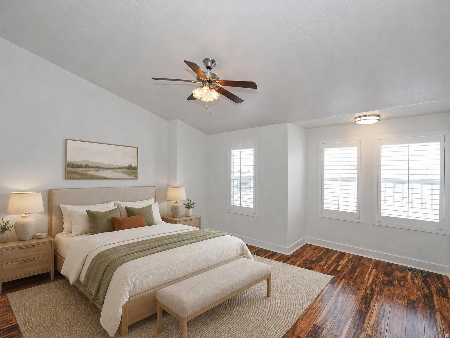Spacious bedroom featuring wood-finish flooring, multiple windows with white plantation shutters, and a ceiling fan with integrated lighting