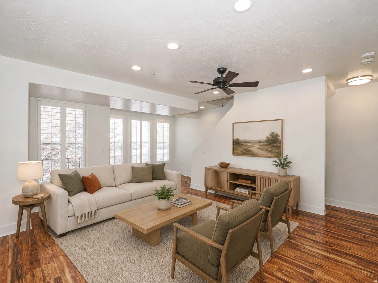 Spacious living area featuring wood-finish flooring, recessed lighting, and a ceiling fan