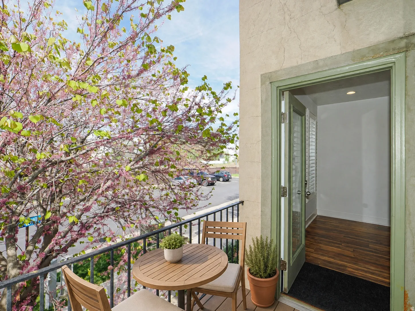 Private balcony featuring a black wrought iron railing, stucco exterior, and a double French door entry with a light green frame