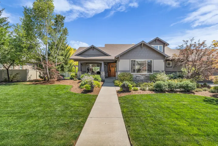 Craftsman-style residence featuring a prominent front gable, shingle siding, and stone accents