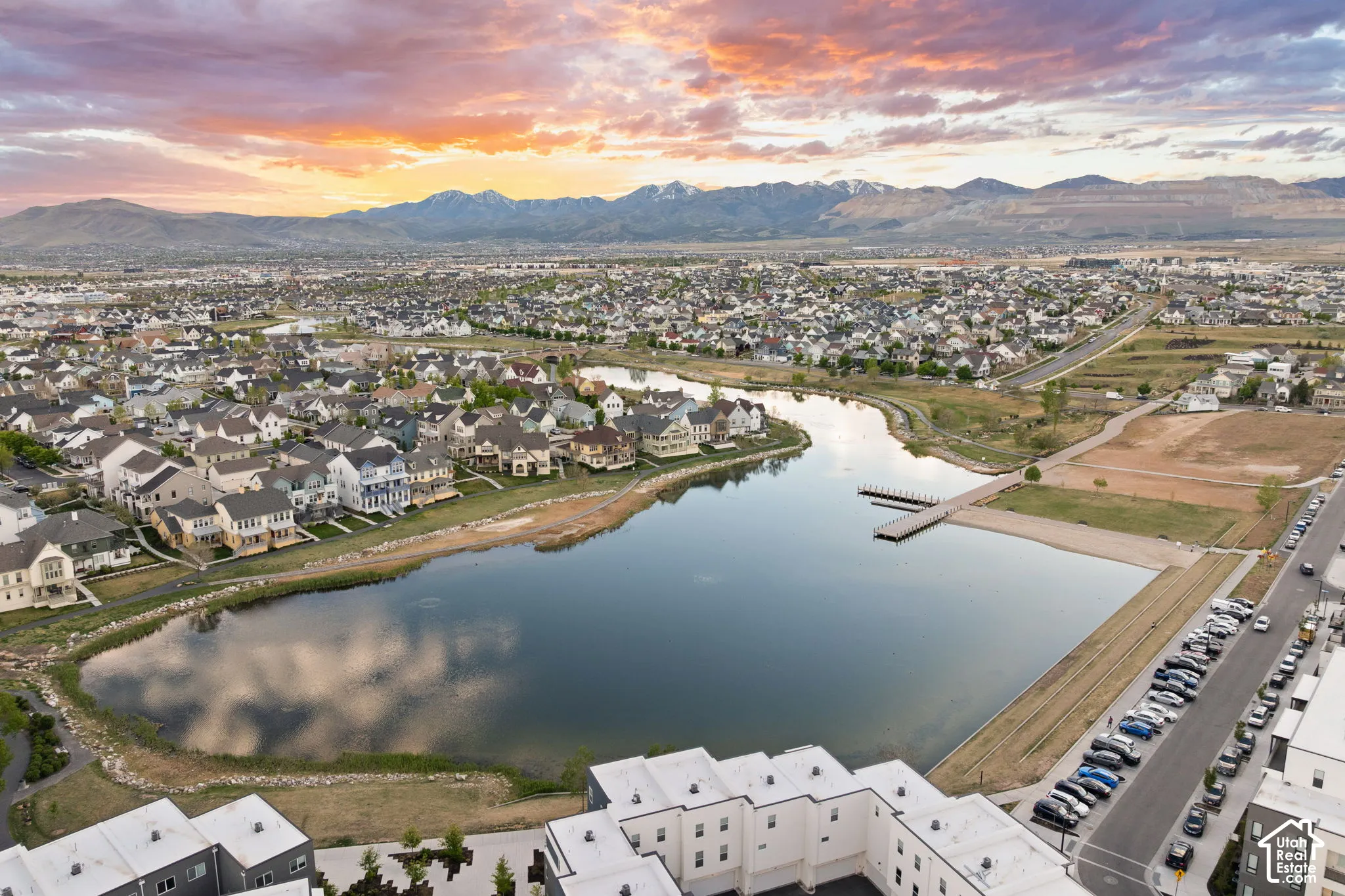 Aerial perspective showcasing a residential community with a large central pond