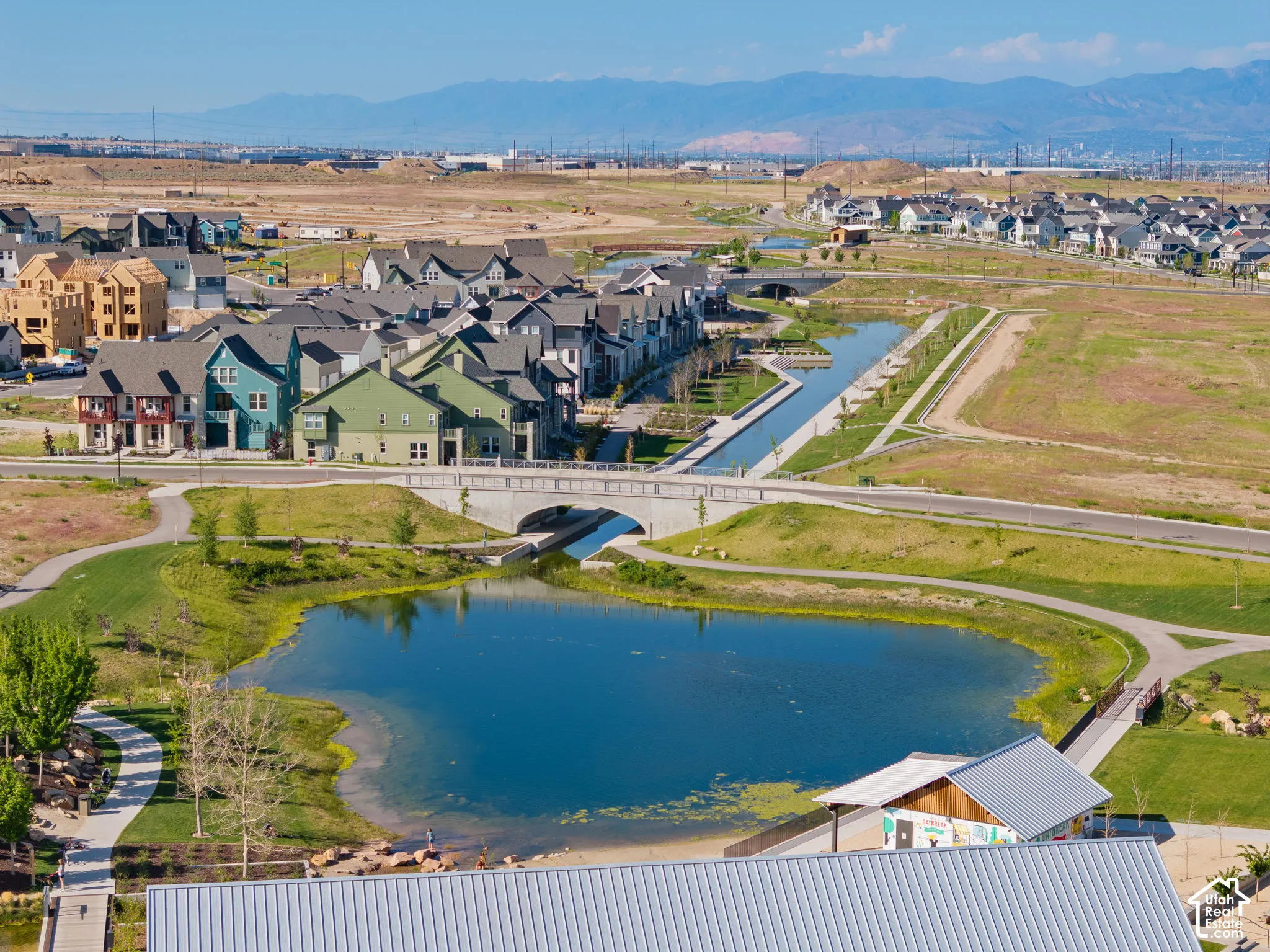 Aerial perspective showcasing a residential community with a large pond and walking paths