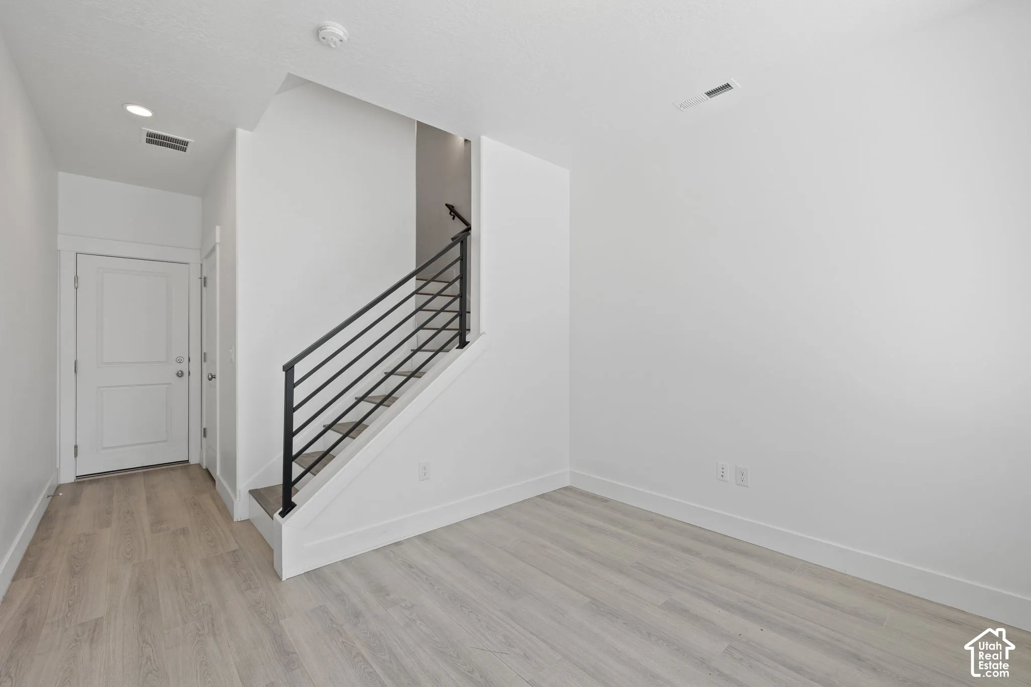 Bright entry/office room featuring light wood-finish flooring, neutral color scheme and natural light
