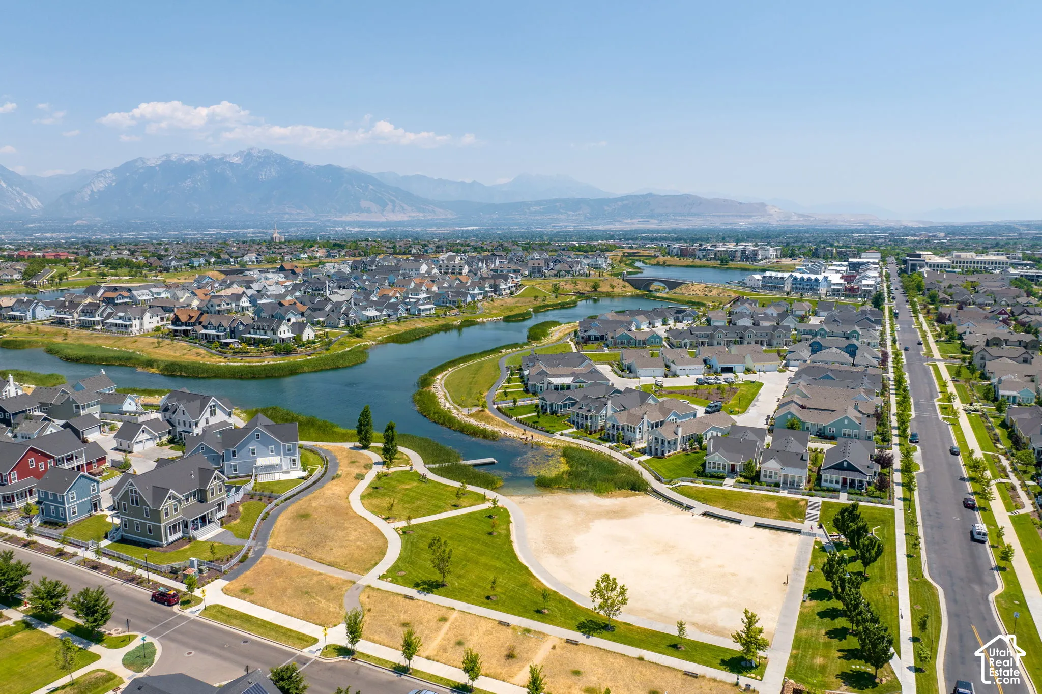 Aerial perspective of a structured residential community featuring a prominent central waterway