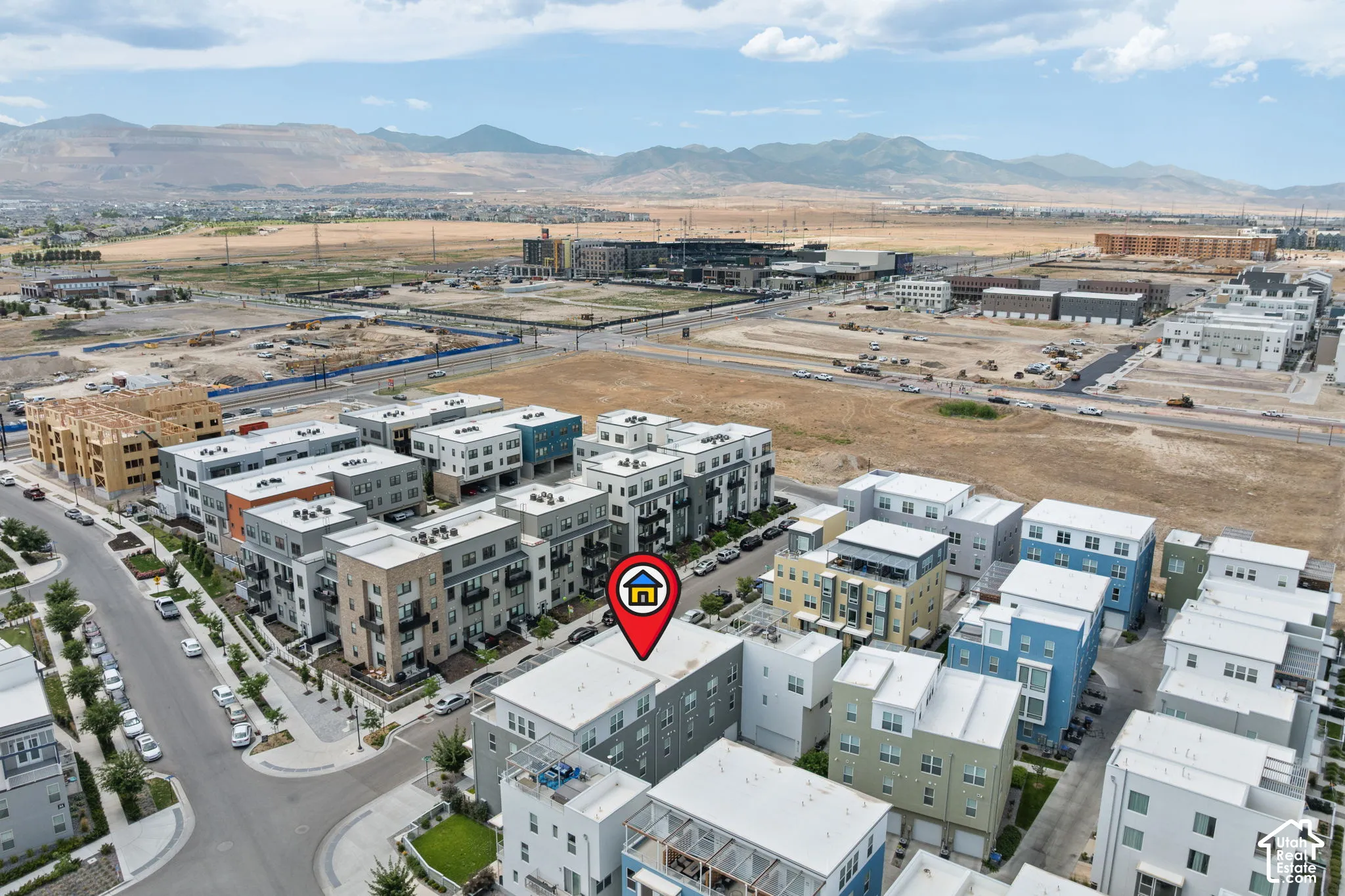 Aerial perspective of a contemporary residential development featuring multi-story townhomes with flat roofs and varying exterior finishes