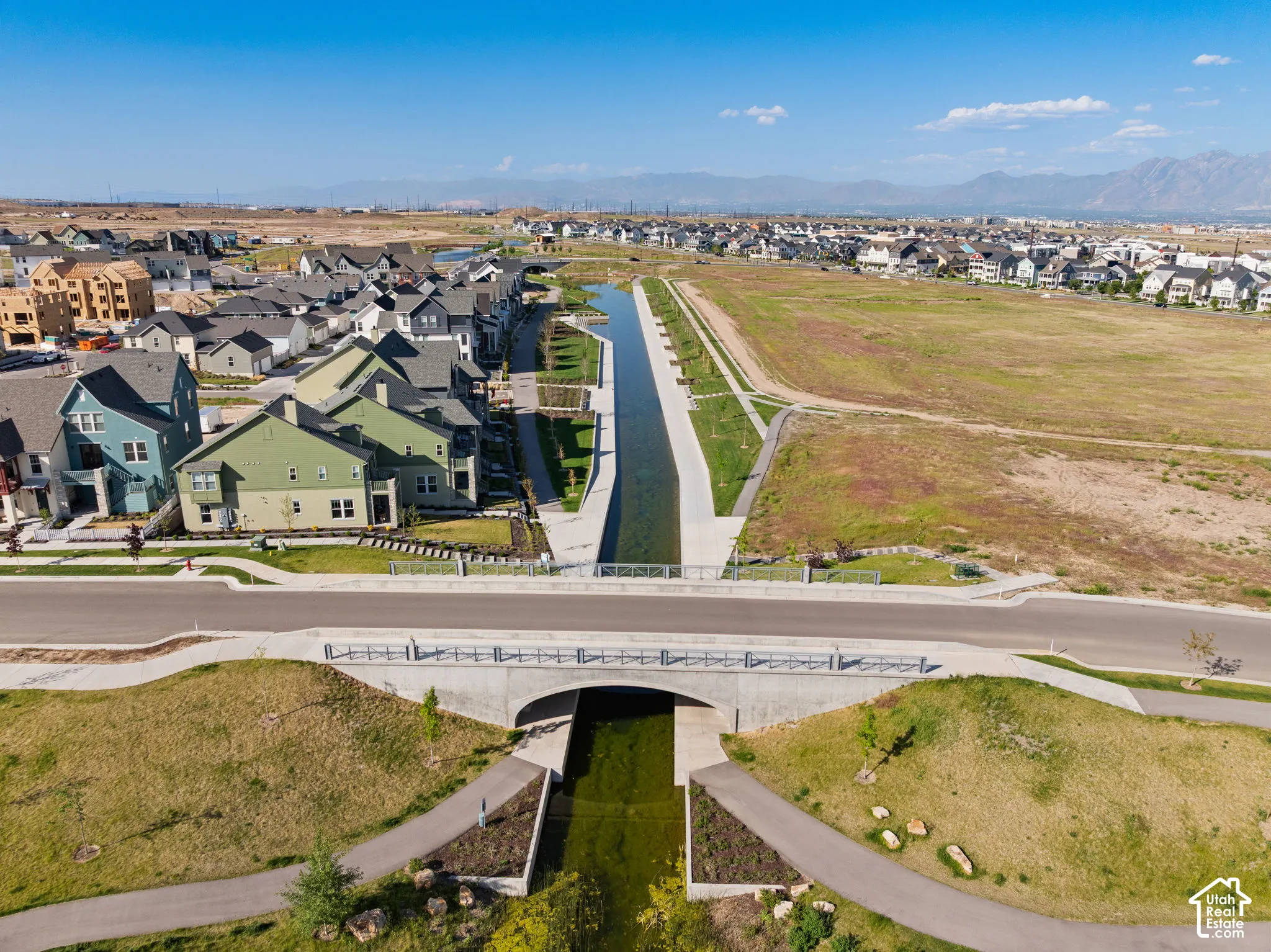 Modern residential architecture bordering a concrete canal with walking paths and bridges