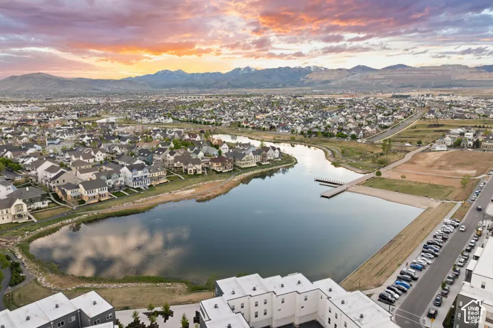 Aerial perspective showcasing a residential community with a large central pond