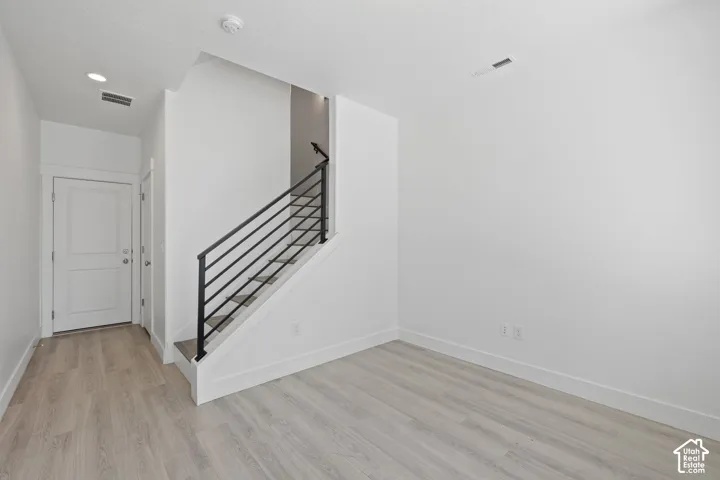 Bright entry/office room featuring light wood-finish flooring, neutral color scheme and natural light