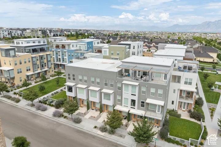 Modern townhome facade featuring a flat roofline, stucco exterior, bay windows, and private balconies