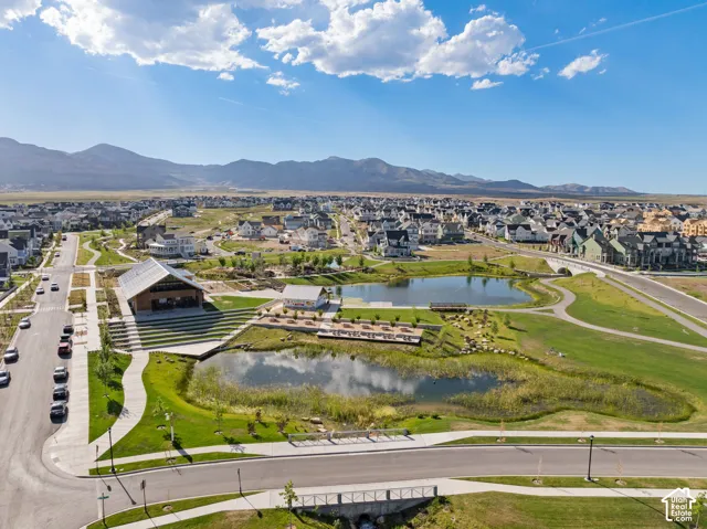 Community green space featuring a large central building with a pitched roof, an amphitheater, and two ponds