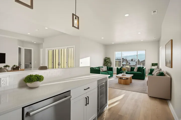 Light wood-finish flooring, recessed lighting, and a kitchen island with a built-in dishwasher