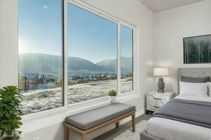 Expansive window offering mountain scenery, light-colored walls, recessed lighting, and soft grey carpeting