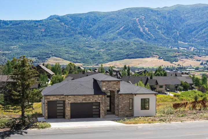 Stone and horizontal siding exterior with a dark shingle roof