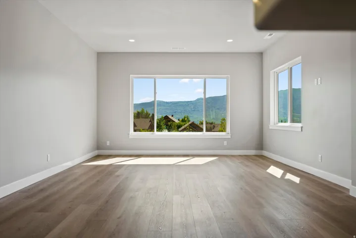 Expansive interior featuring wood-finish flooring, recessed lighting, and multiple windows with white trim