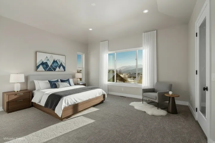 Recessed lighting, large picture windows, grey carpeting, white interior doors, and a neutral color palette