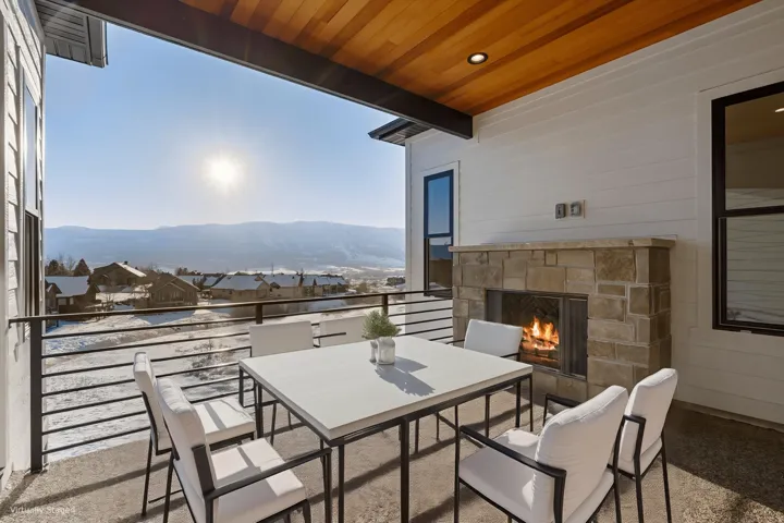Expansive outdoor deck featuring an integrated stone-clad fireplace and wood-finish ceiling