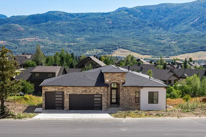 Stone and siding exterior with a dark asphalt shingle roof