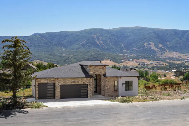 Modern residence featuring a striking stone and stucco exterior with a flat roofline and architectural detail