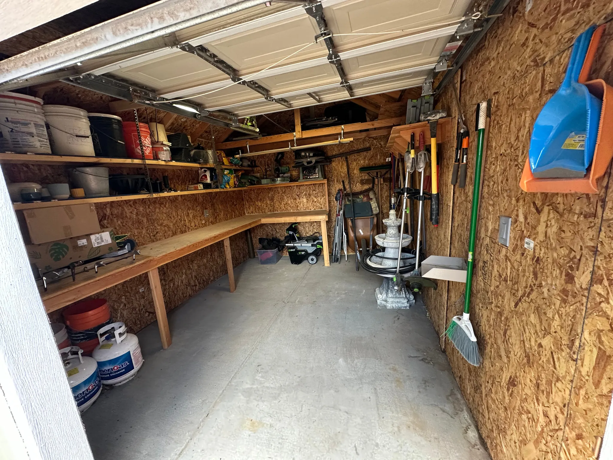 Utility shed with wood-finish paneling and concrete flooring