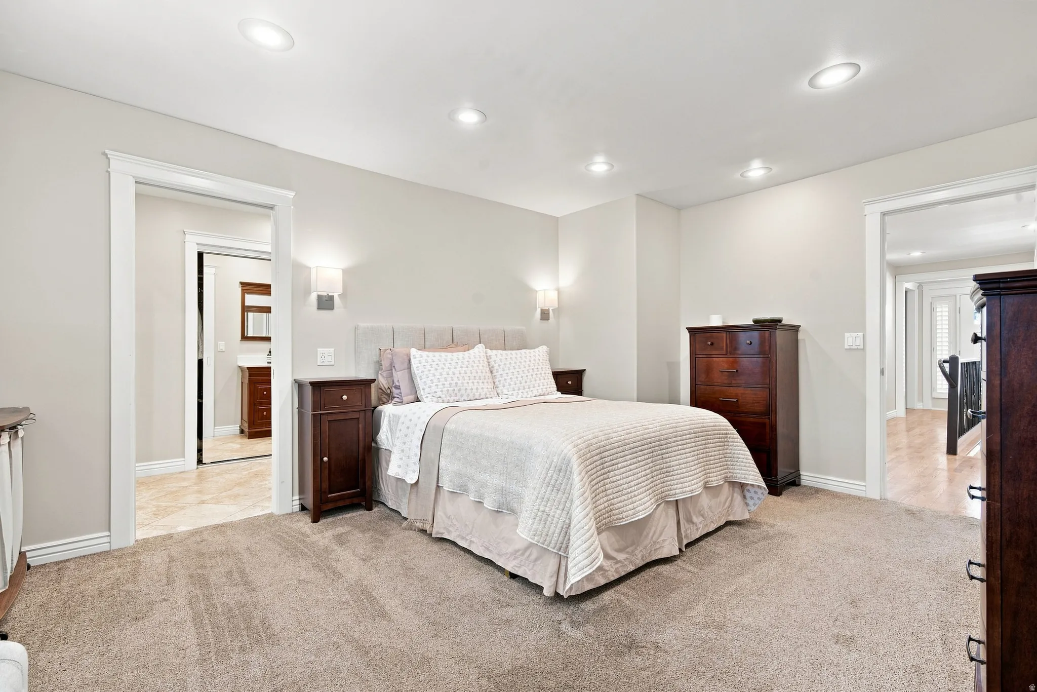 Carpeted Master bedroom featuring recessed lighting and wall sconces