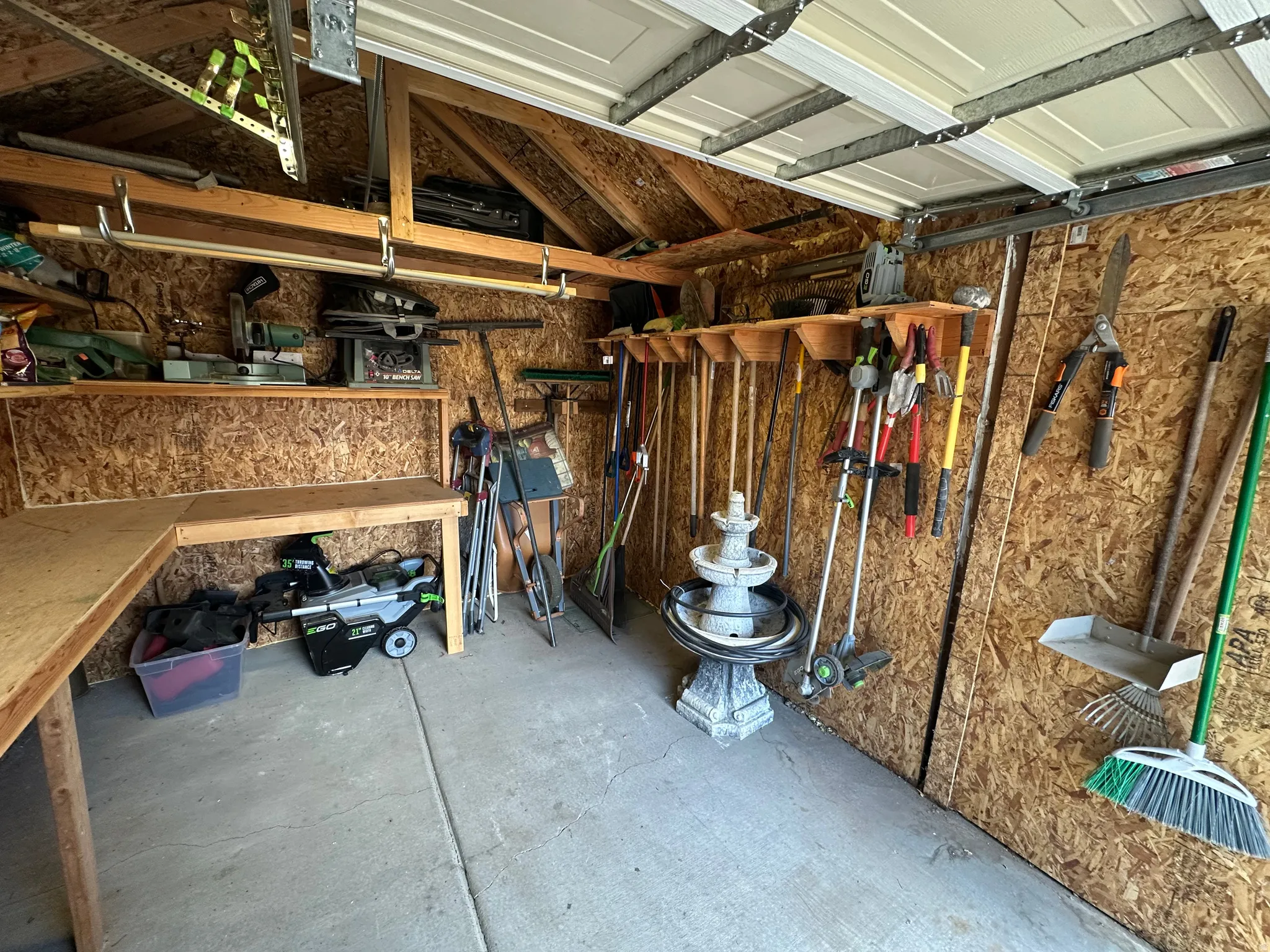 Utility shed interior featuring concrete flooring and wood-finish walls