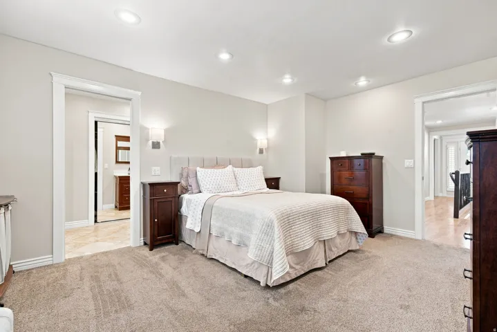 Carpeted Master bedroom featuring recessed lighting and wall sconces