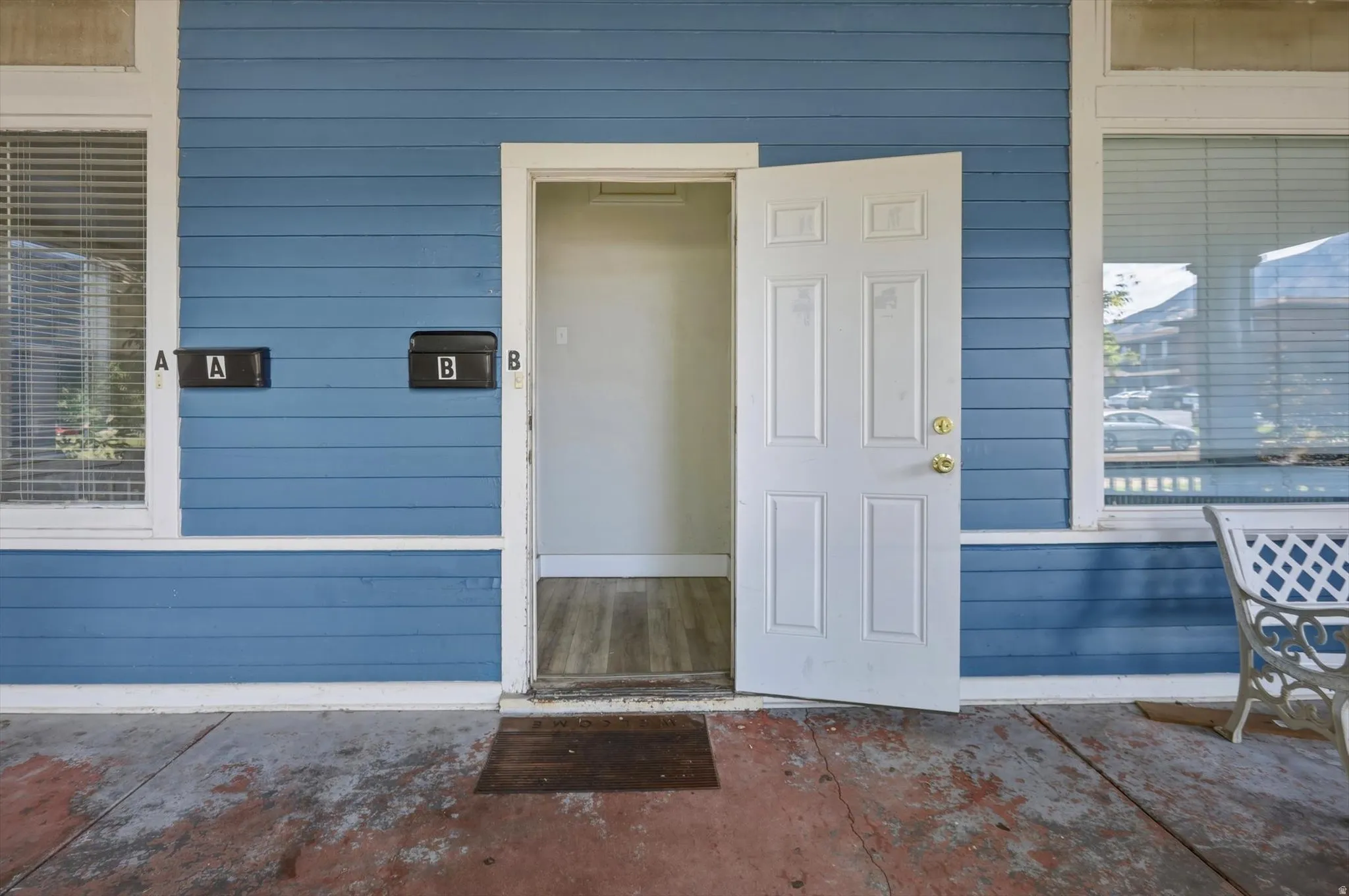 Shared front door into foyer with two separate doors to apartments