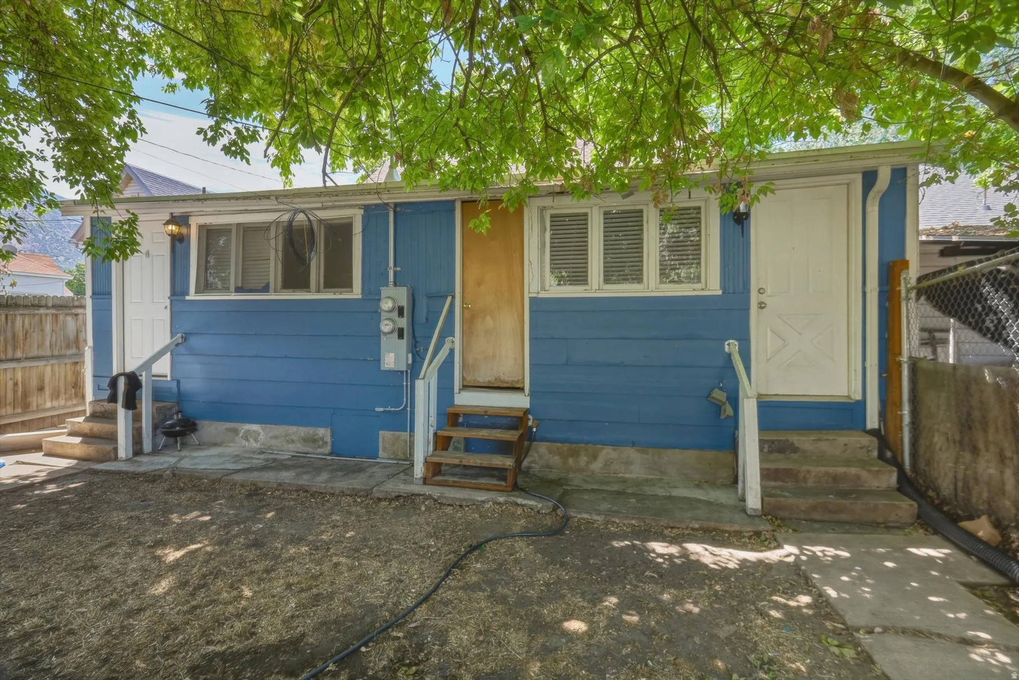 Rear exterior with white apartment doors and shared middle door to laundry