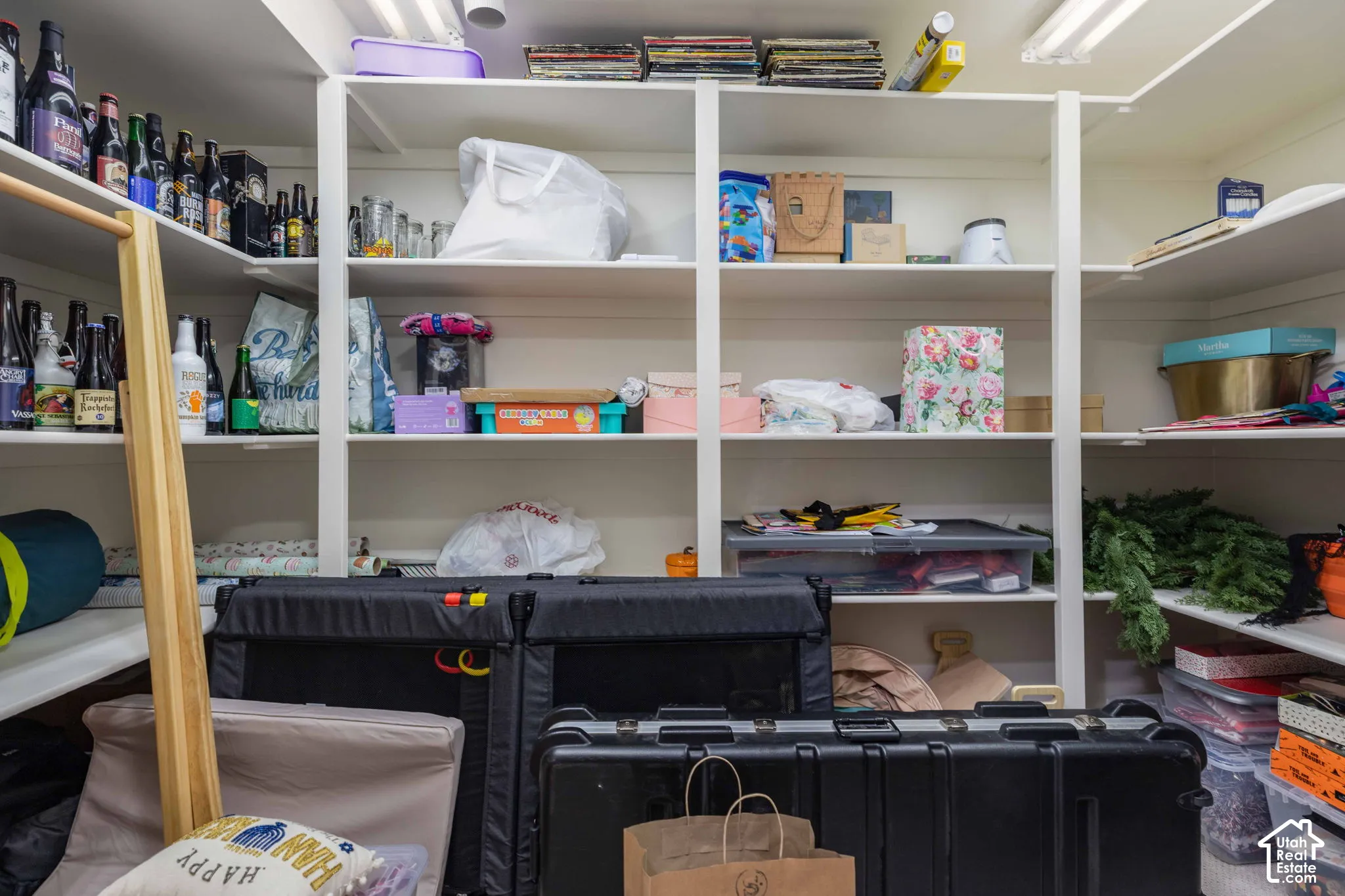 Built-in white shelving system featuring multiple tiers of storage, integrated lighting, and a corner configuration