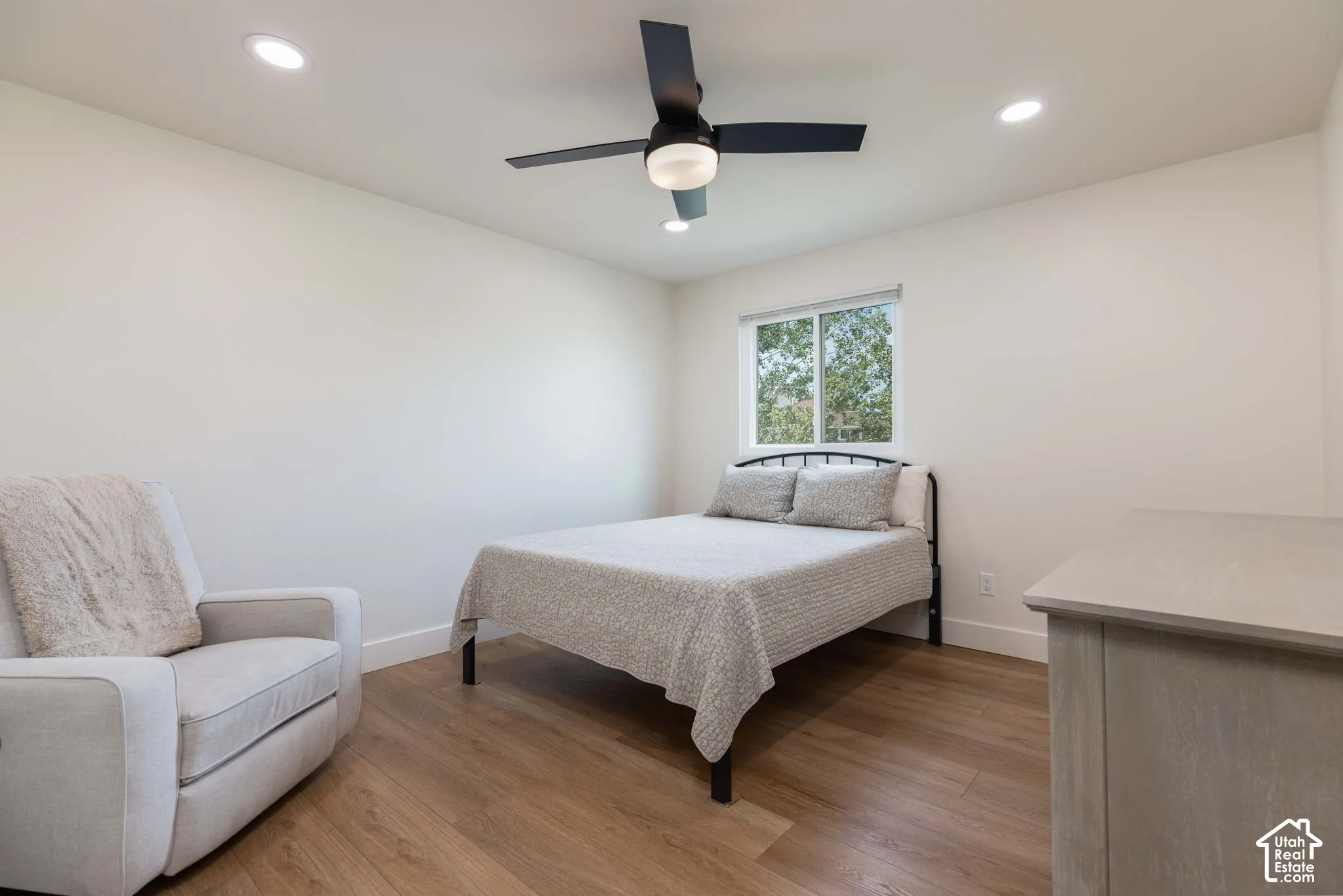 Bright room featuring recessed lighting, a modern ceiling fan, a window, and wood-finish flooring