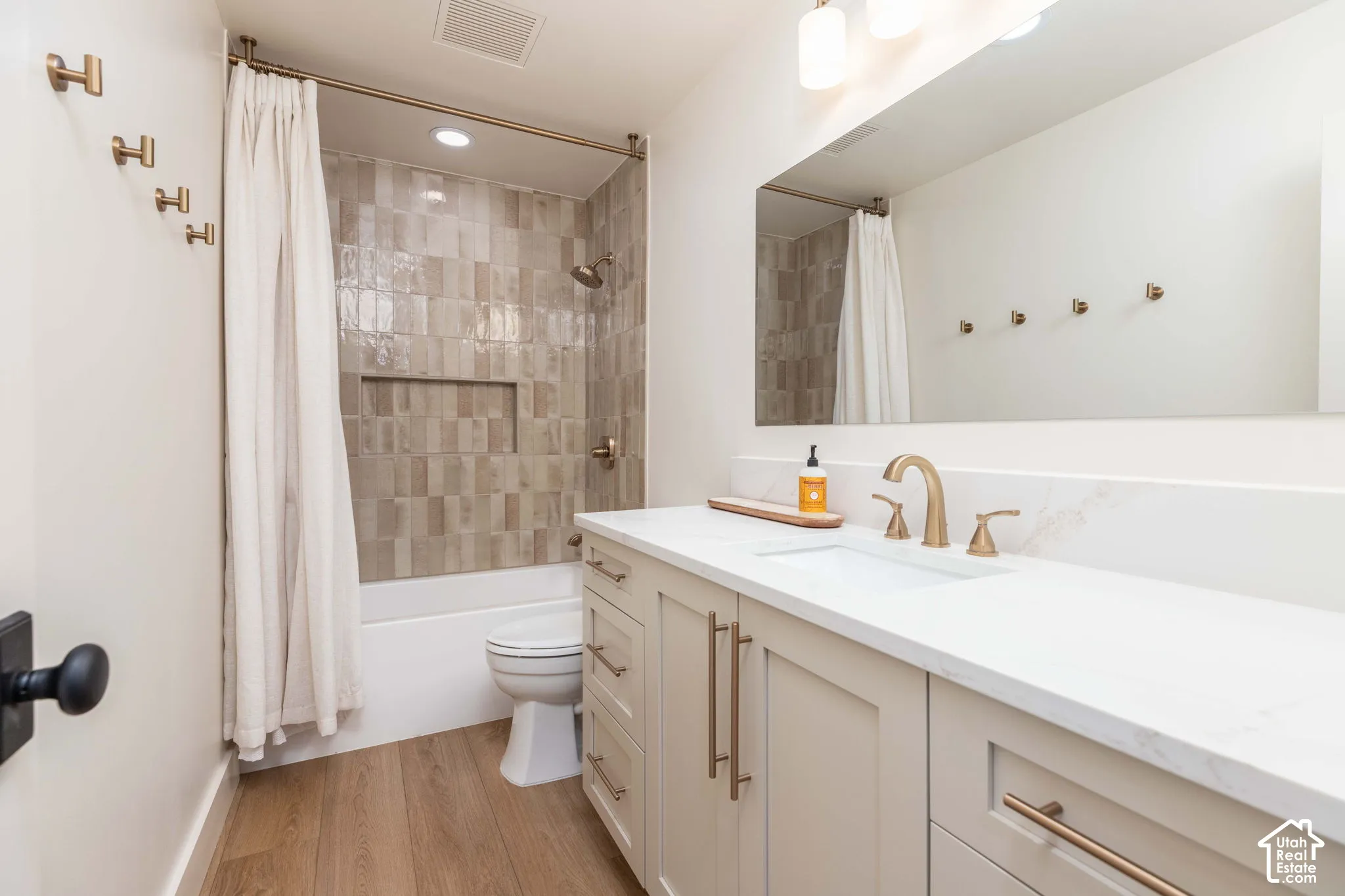 Bathroom with a single vanity, undermount sink, and light-toned cabinetry