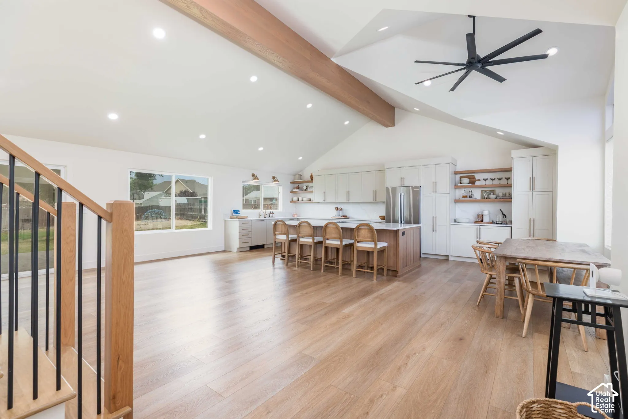 Open concept living space featuring wood-finish flooring, vaulted ceilings with a wood beam, and recessed lighting