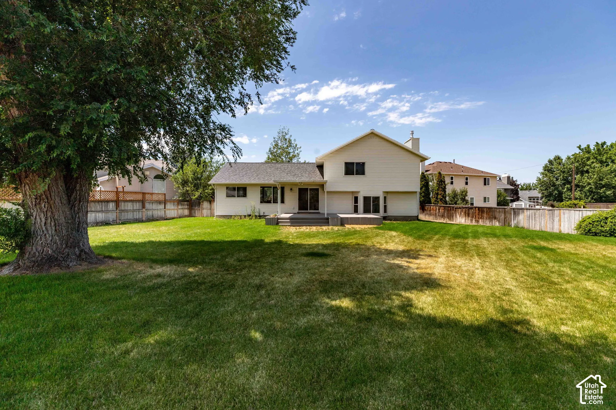 Spacious backyard with a large mature tree providing shade